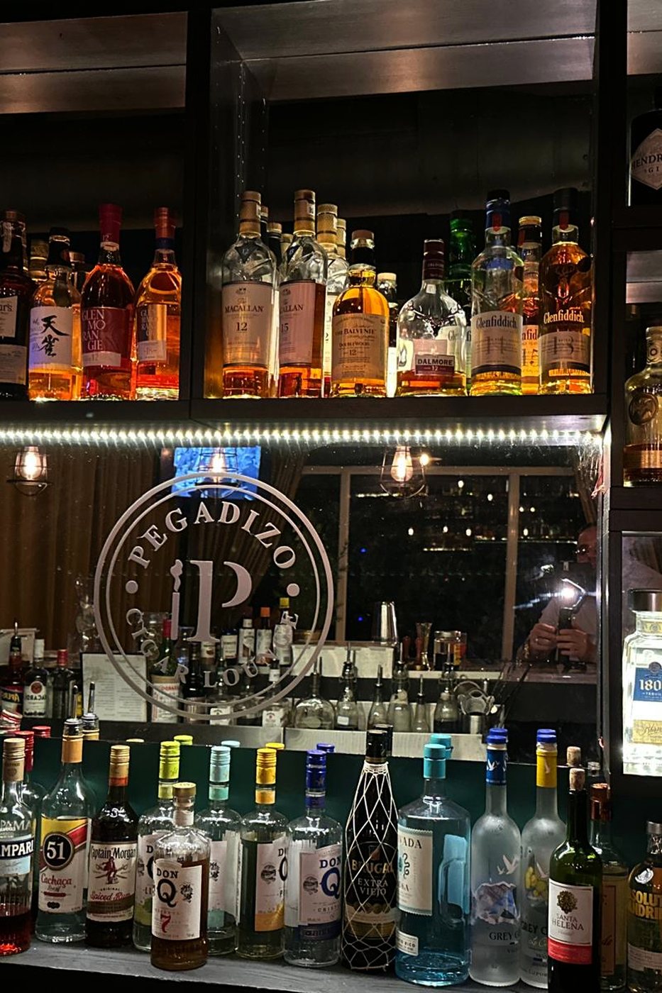 La estanteria de botellas de Pegadizo, con el logo grabado en el cristal