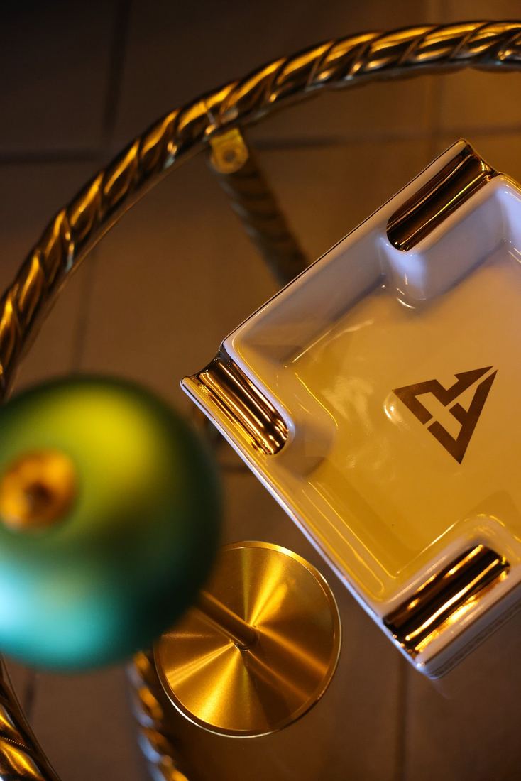 Cenicero de la casa junto a una copa, en detalle