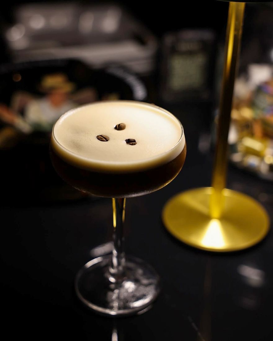 Un coctel con espuma y tres puntos de amargo encima