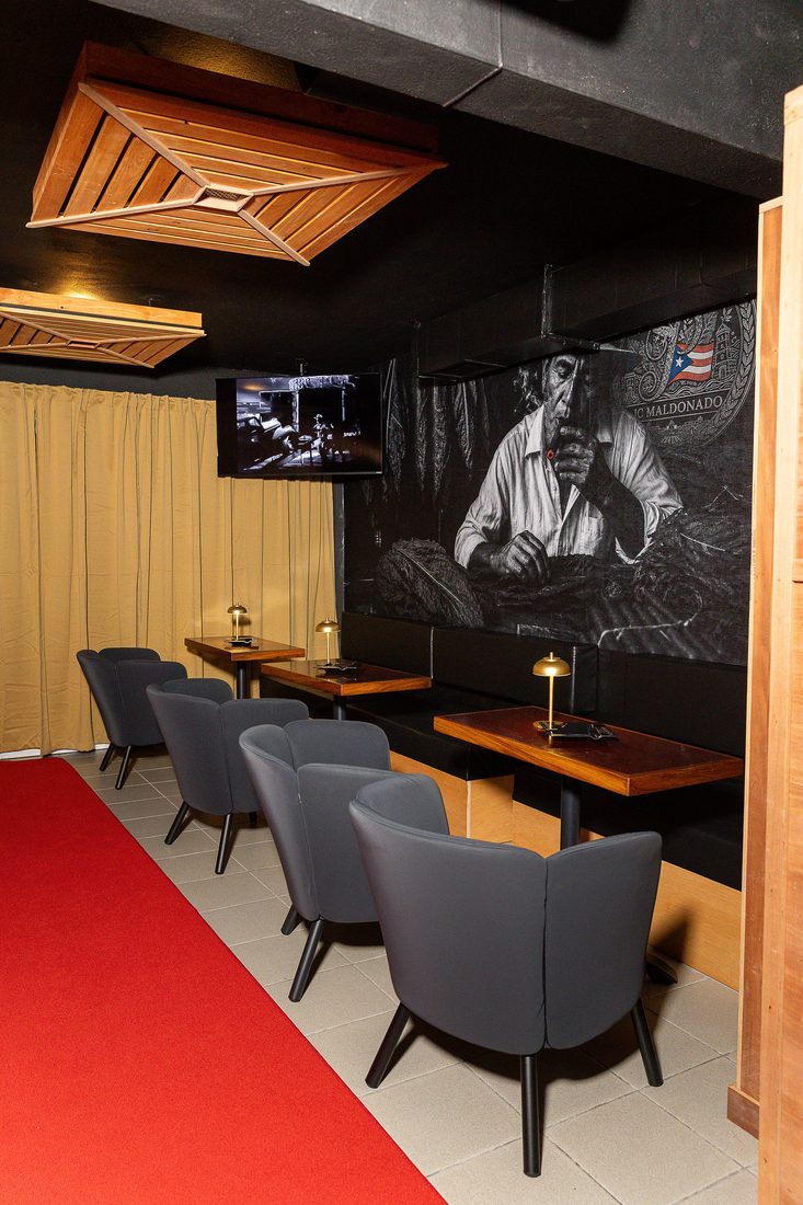El speakeasy privado, con el mural del torcedor y la alfombra roja