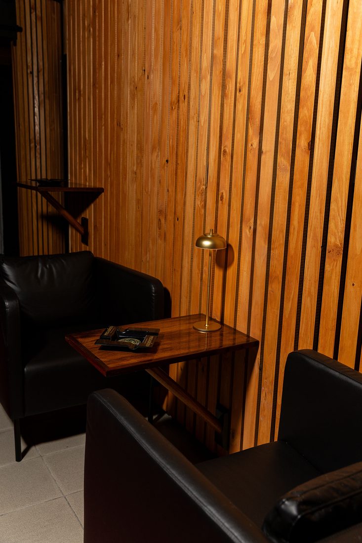 La pared de listones de cedro del speakeasy, con el sofa y la mesa